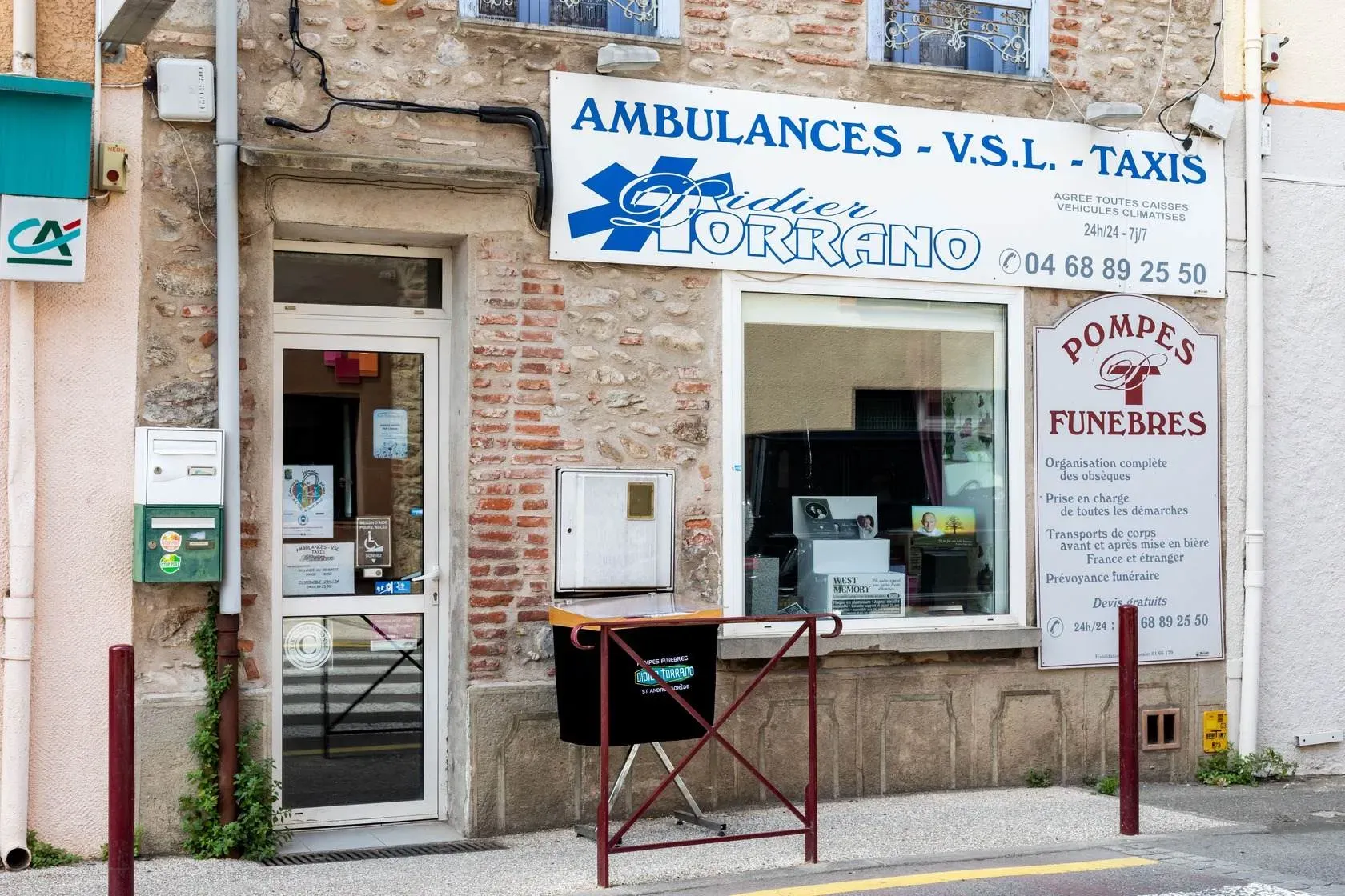 Entrée de l'agence de pompes funèbres, ambulances et taxis avec affichage des services.